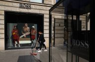 Fachada de uma loja da Hugo Boss, com uma moça varrendo a rua logo em frente