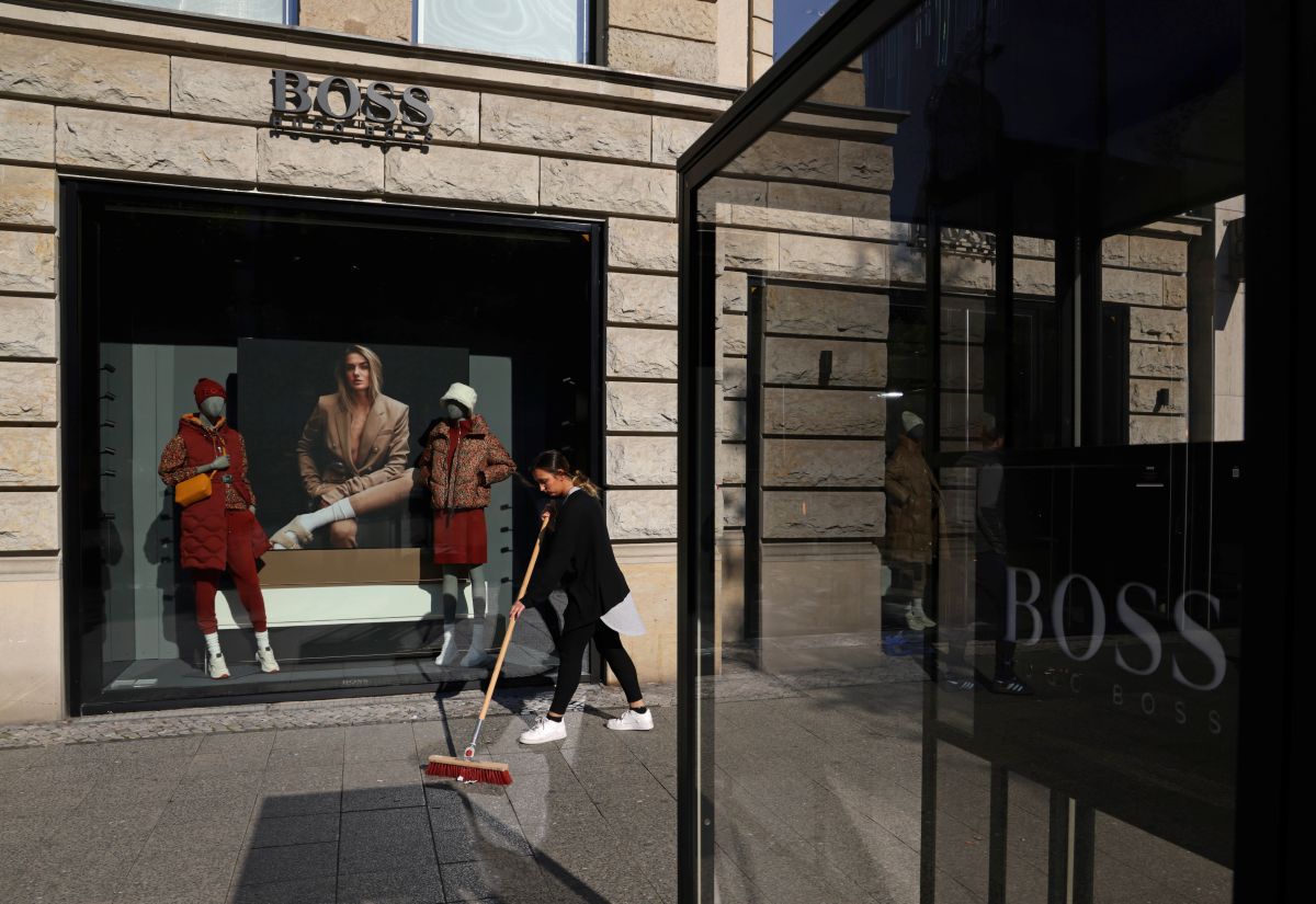 Fachada de uma loja da Hugo Boss, com uma moça varrendo a rua logo em frente