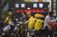 Imagem de entregadores de comida da Meituan, na China, todos de camiseta amarela e capacete amarelo
