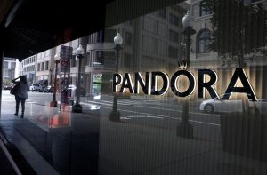 Fachada da loja Pandora, que vende joias, logotipo é preto, iluminação está por traz de cada letra