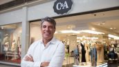 Paulo Correa (homem branco de braços cruzados), CEO da C&A, posa em frente a uma loja