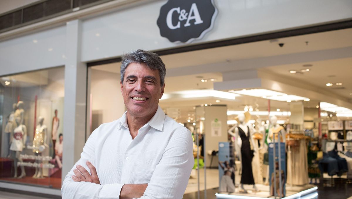 Paulo Correa (homem branco de braços cruzados), CEO da C&A, posa em frente a uma loja
