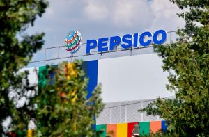 Imagem da fachada da Pepsico, com letreiros azul e um muro branco