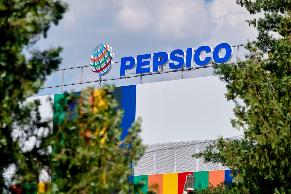 Imagem da fachada da Pepsico, com letreiros azul e um muro branco