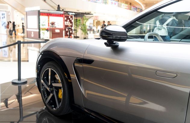 Frente de um carro Xiaomi prata que está dentro de um shopping