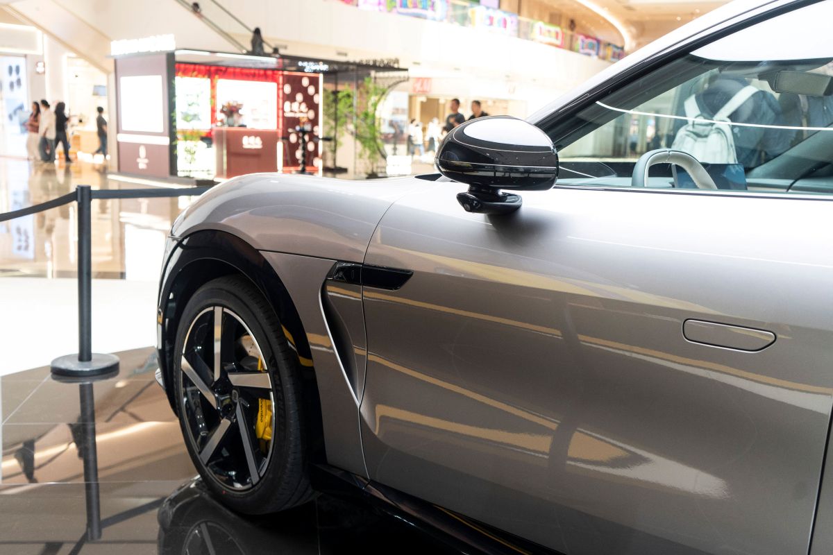 Frente de um carro Xiaomi prata que está dentro de um shopping