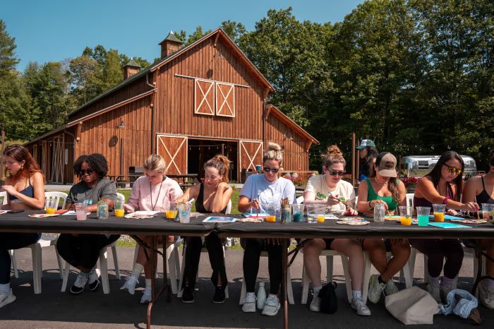 Americanos em acampamento, sentados numa mesa ao sol