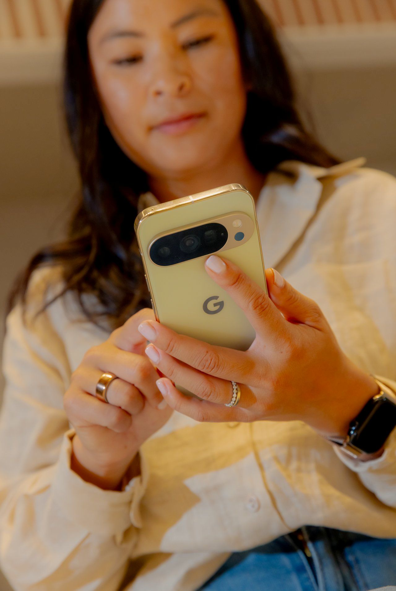 Moça segura um smartphone do Google