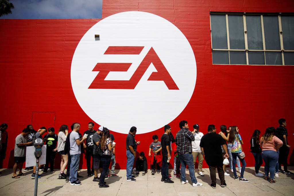 Logo da Eletronic Arts (EA) com pessoas fazendo fila para adquirir games