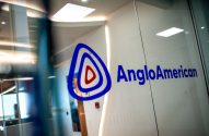 Logotipo da Anglo American em azul, numa porta de vidro transparente