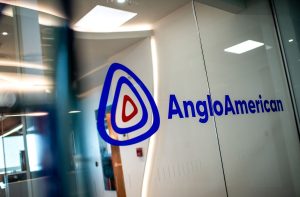Logotipo da Anglo American em azul, numa porta de vidro transparente