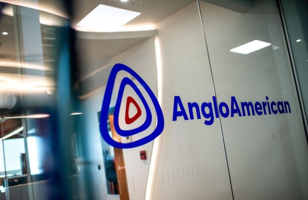 Logotipo da Anglo American em azul, numa porta de vidro transparente