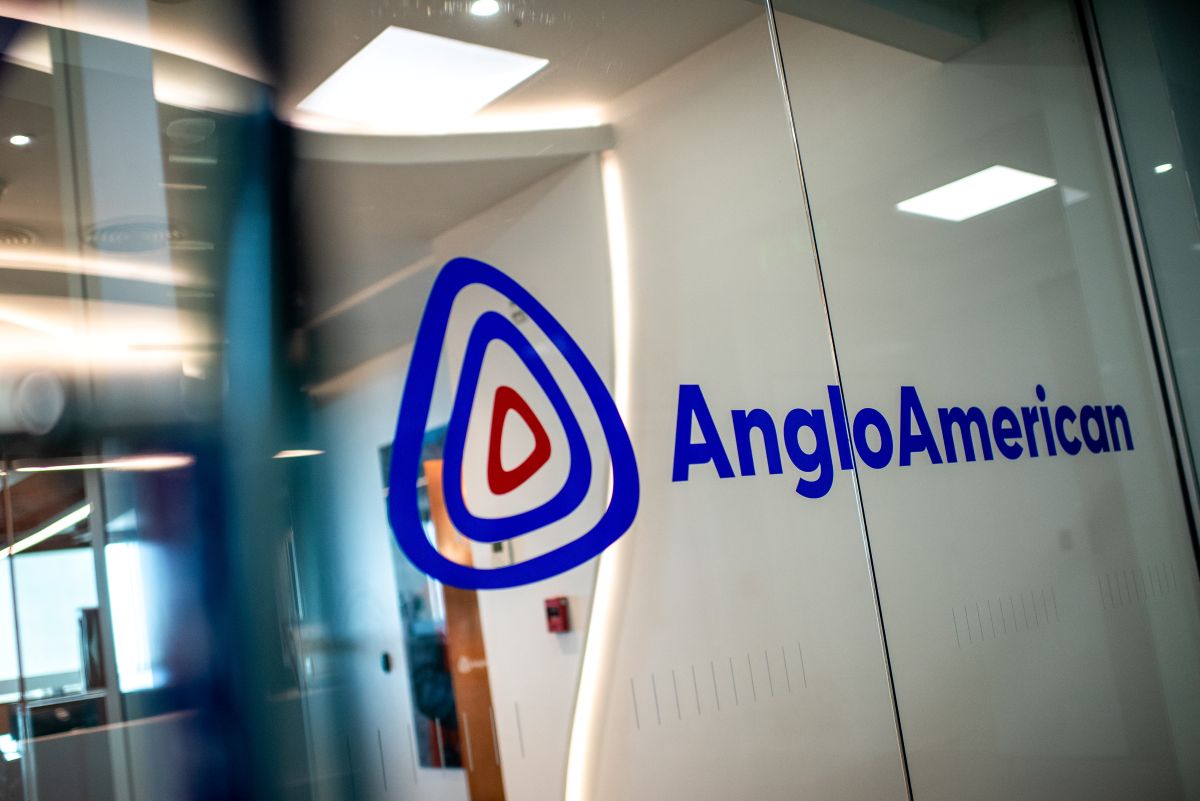Logotipo da Anglo American em azul, numa porta de vidro transparente