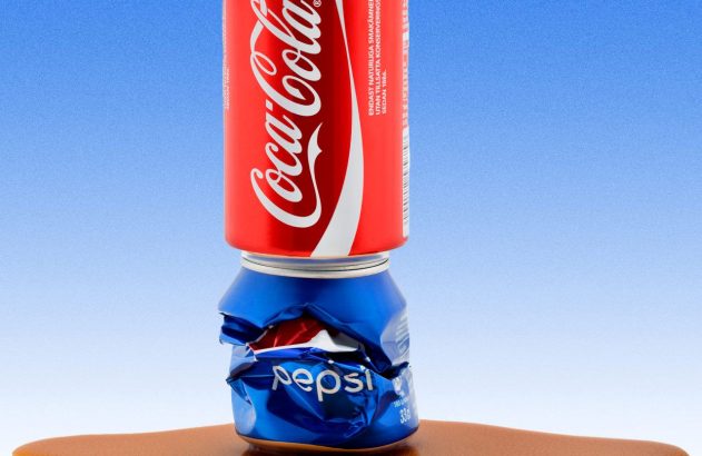 Imagem de uma lata de Coca-Cola em cima de uma da Pepsi, toda amassada