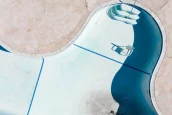 an empty pool with a chair and a ladder