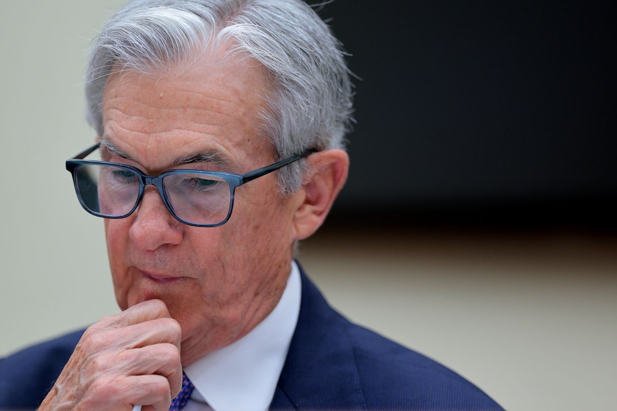 Jerome Powell é presidente do Fed, um senhor de cabelos grisalhos e óculos pretos quadrados, está segurando o queixo, de terno preto e camisa branca