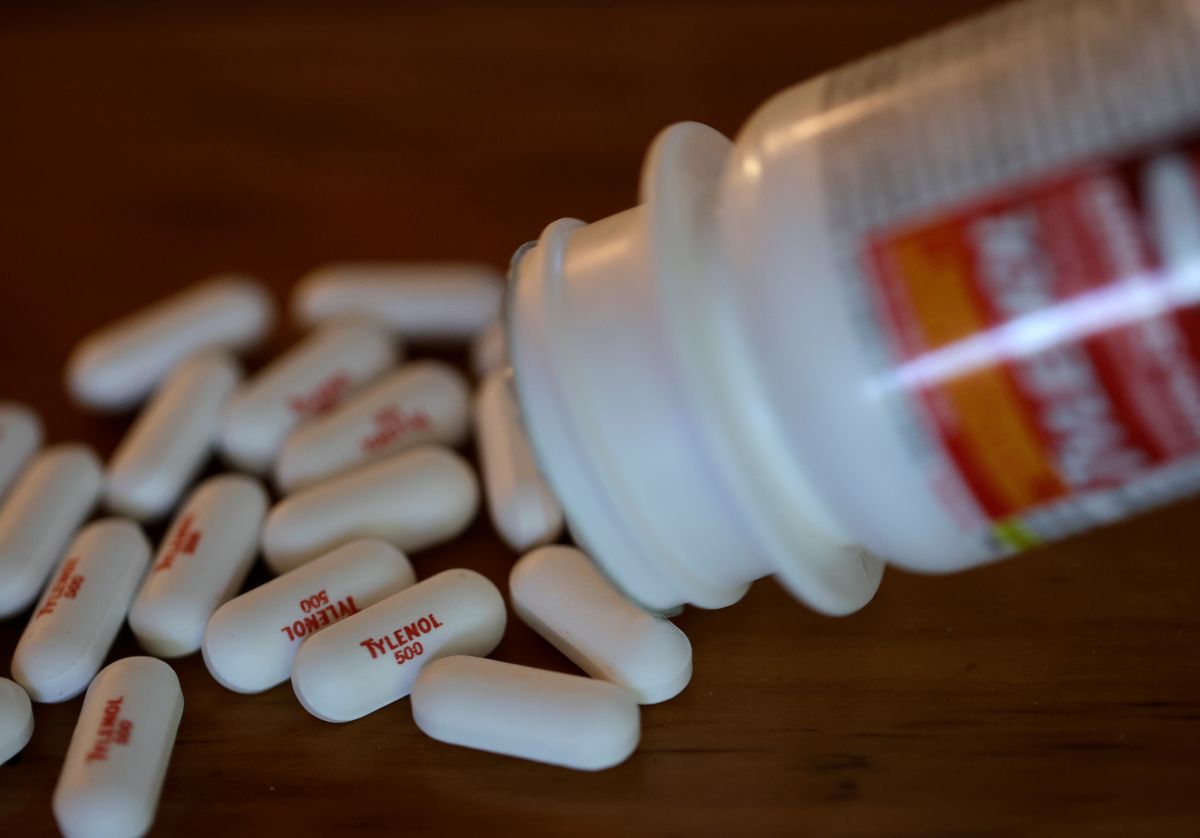 Imagem de um pote de Tylenol aberto e diversas pílulas na mesa