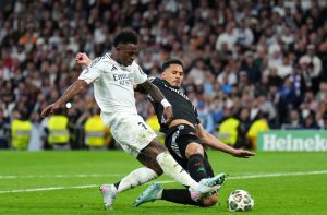 Vinicius Junior e William Saliba disputam bola