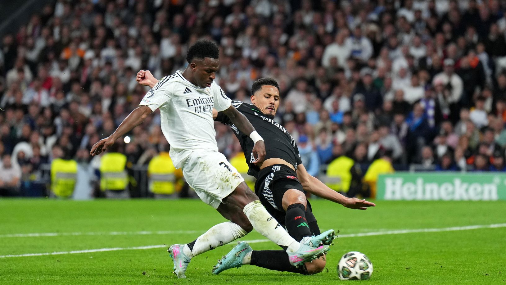 Vinicius Junior e William Saliba disputam bola