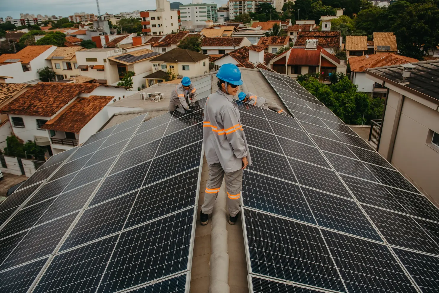a group of men standing on a roof with solar panels