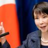 Nova premiê do Japão é uma mulher de cabelos escuros e curtos, está vestindo um blazer cinza e colar de pérolas