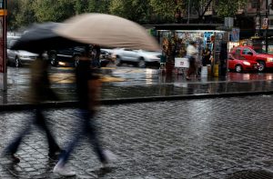 Foto da Cidade do México com pessoas de sombrinha, com chuva