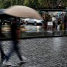 Foto da Cidade do México com pessoas de sombrinha, com chuva