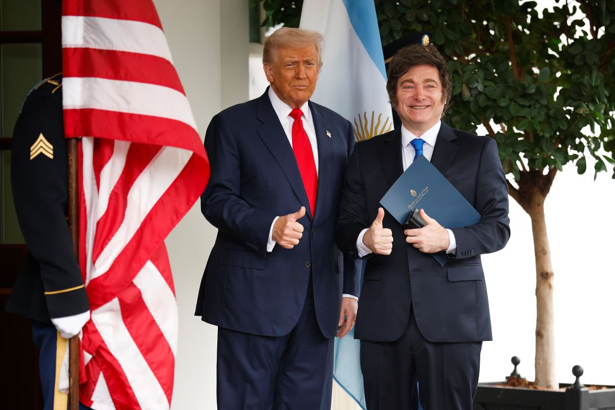 Donald Trump está de terno preto e gravata vermelha ao lado de Javier Milei, mais baixo, de terno preto e gravata escura