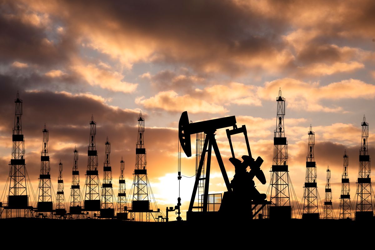Extração de petróleo com várias maquinas em um céu cheio de nuvens
