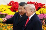 Os presidentes da China e dos EUA estão lado a lado em frente a flores coloridas