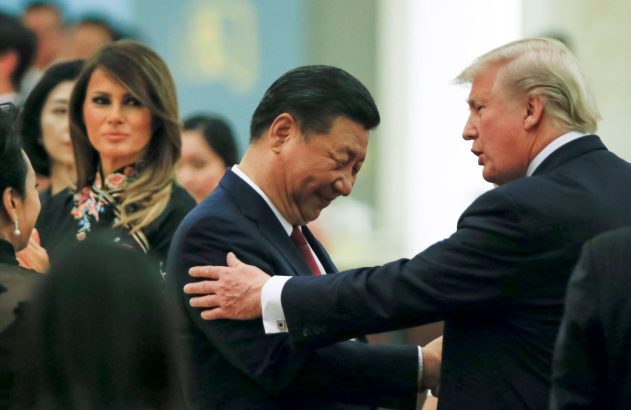 Donald Trump cumprimenta Xi Jinping, ambos de terno escuros e sorrindo