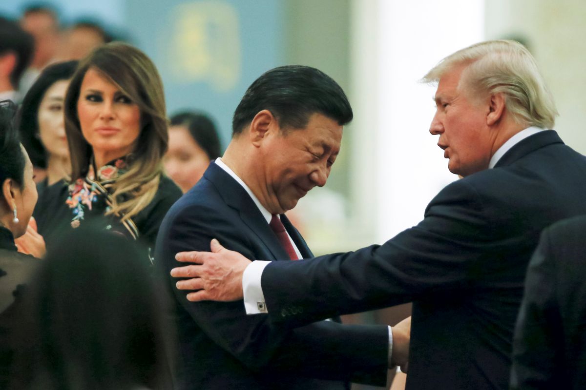 Donald Trump cumprimenta Xi Jinping, ambos de terno escuros e sorrindo