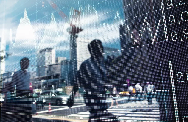 Reflexo de pessoas atravessando rua em frente a prédios, com gráfico financeiro exibido sobreposto no vidro.