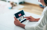 Imagem de uma mulher olhando promoções da Black Friday em um tablet para ilustrar reportagem sobre a Black Friday 2025