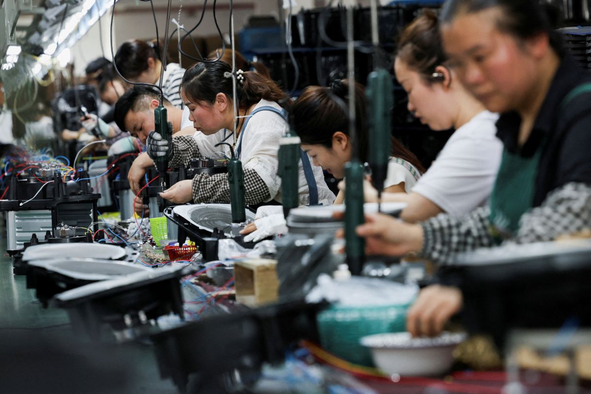 Chineses trabalhando em uma fábrica de costura