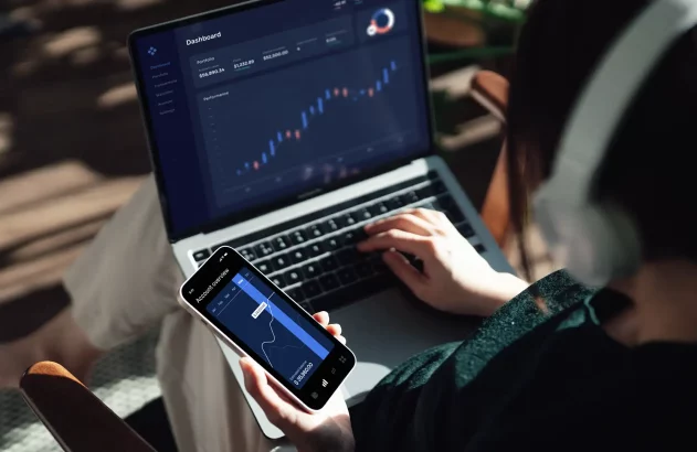 imagem de uma pessoa usando um celular e um notebook para ilustrar reportagem sobre 13º salário 2025