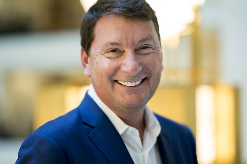 Imagem de um lobista dos EUA, Brian Ballard, um homem de meia idade, sorrindo para a câmera com terno azul e camisa branca