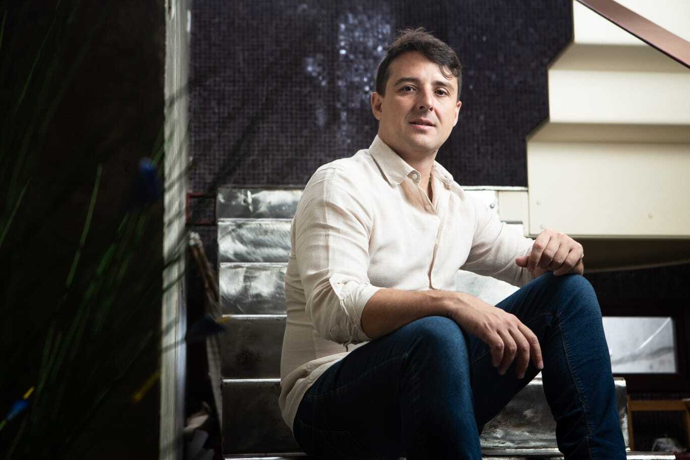 Nero, fundador da rede de academias Ultra, sentado em uma escada