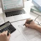 Imagem de uma mesa com papéis, notebook, calculadora etc para ilustrar guia Imposto de Renda 2026: como declarar? Confira guia completo