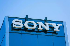 Logotipo branco da Sony no topo de um edifício comercial com fachada de vidro azul.