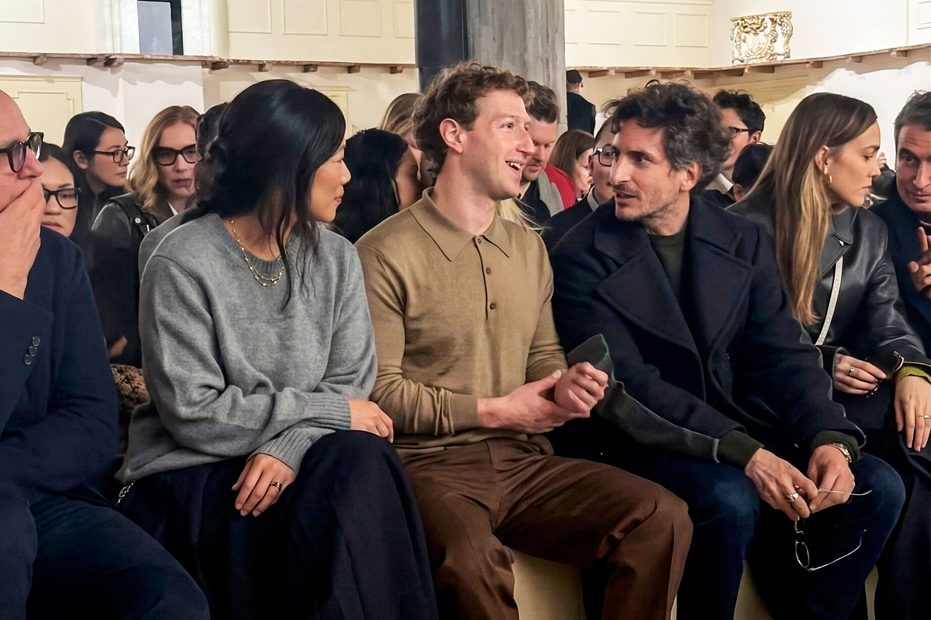 Mark Zuckerberg e Priscilla Chan na primeira fila do desfile da Prada em Milão; ao lado do CEO da Meta está Lorenzo Bertelli, executivo da grife italiana e filho de Miuccia Prada