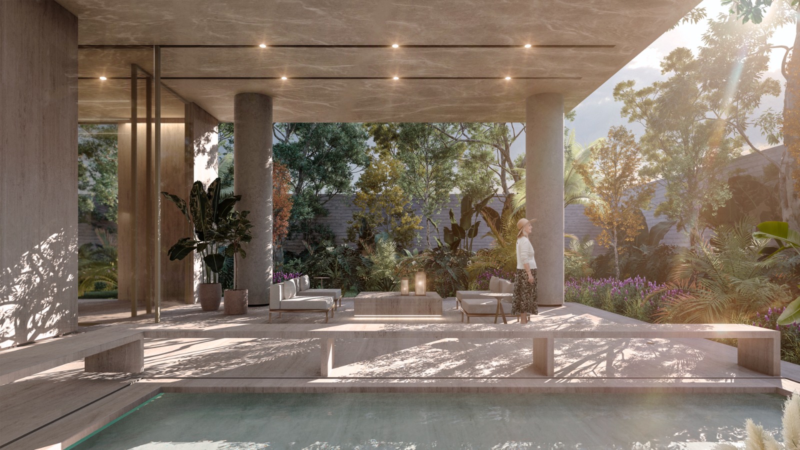 Área comum de edifício residencial com pé-direito alto, pilares de concreto e mobiliário contemporâneo. Uma mulher caminha pelo ambiente iluminado por luz natural.